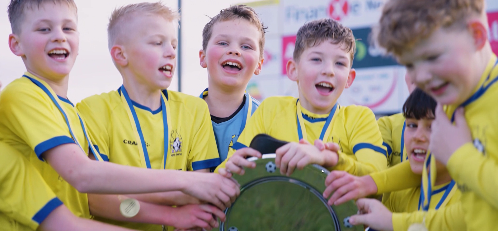 Jeugdspelers van vv Staphorst vieren de titel, in geel-blauw shirt met medaille en beker